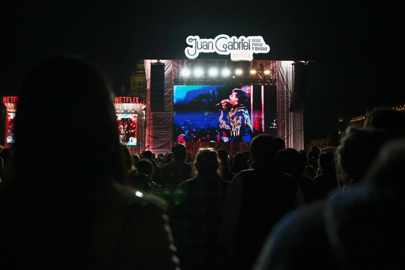 El público disfruta de una proyección gratuita del concierto que el fallecido cantante mexicano Juan Gabriel ofreció en 1990 en Bellas Artes, en el Zócalo, la plaza principal de la Ciudad de México, el sábado 8 de noviembre de 2025. (Foto AP/Claudia Rosel)