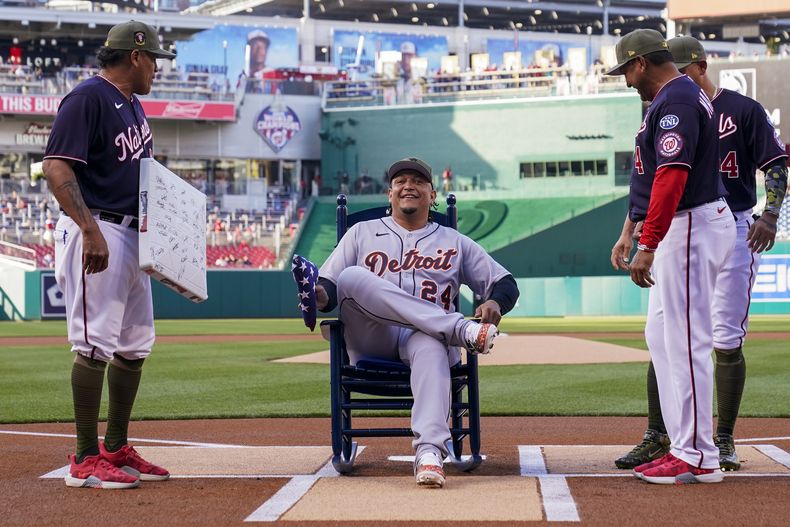 El venezolano Miguel Cabrera ríe sentado en una mecedora que le obsequiaron losN Nacionales de Washington, antes del juego del viernes 19 de mayo de 2023 (AP Foto/Alex Brandon)