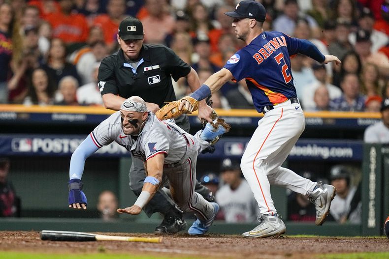 Royce Lewis, de los Mellizos de Minnesota, es tocado y puesto fuera por el tercera base de los Astros de Hpuston, Alex Bregman, durante la quinta entrada del Juego 2 de la Serie Divisional de la Liga Americana, en Houston, el domingo 8 de octubre de 2023. (AP Foto/Kevin M. Cox)
