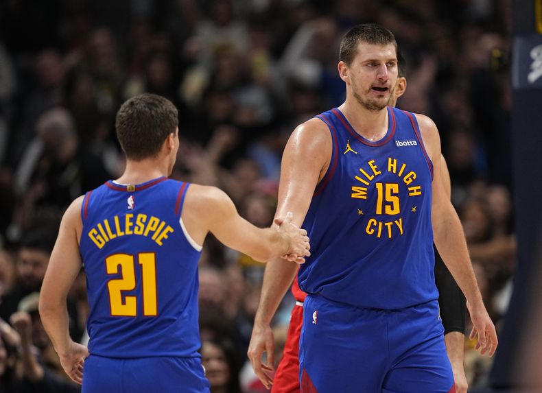 El serbio Nikola Jokic, pívot de los Nuggets de Denver, festeja con Collin Gillespie tras encestar ante los Bulls de Chicago, el sábado 4 de noviembre de 2023 (AP Foto/Jack Dempsey)