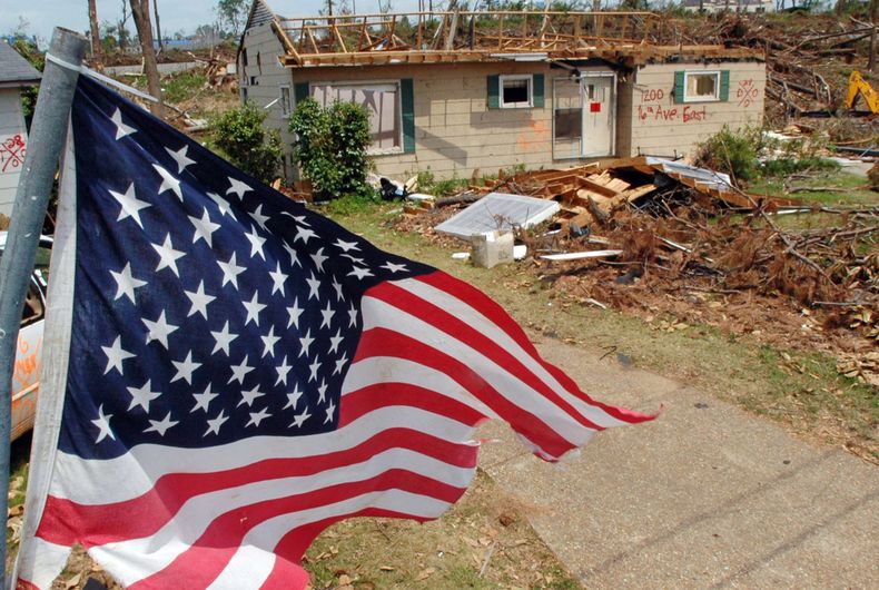ARCHIVO - En esta foto de archivo del 23 de mayo de 2011, una bandera ondea sobre los restos de un barrio asolado por un tornado en Tuscaloosa, Alabama. Oklahoma y Kansas tienen fama de ser los estados m&aacute;s afectados por tornados, pero Florida parec
