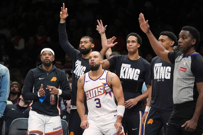 Los jugadores de banca de los Suns de Phoenix celebran después de que Dillon Brooks (3) embocara un triple durante la primera mitad del juego de baloncesto de la NBA frente a los Nets de Brooklyn, el lunes 19 de enero de 2026, en Nueva York. (AP Foto/Frank Franklin II)