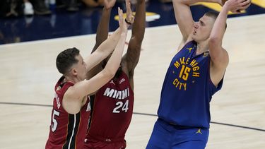 El serbio Nikola Jokic, de los Nuggets de Denver, dispara frente a Duncan Robinson, del Heat de Miami, en el primer partido de las Finales de la NBA, el jueves 1 de junio de 2023 (AP Foto/David Zalubowski)