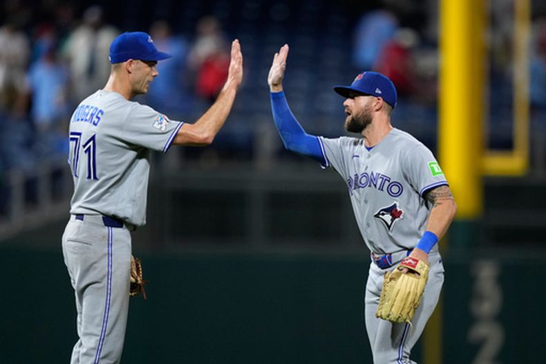 Tyler Rogers (izquierda), de los Azulejos de Toronto, festeja con Nathan Lukes, tras el duelo ante los Filis de Filadelfia, el sábado 8 de agosto de 2026 (AP Foto/Matt Slocum)
