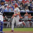 Kevin Newman, de los Rojos de Cincinnati, anota frente al cátcher venezolano Salvador Pérez, de los Reales de Kansas City, el martes 13 de junio de 2023 (AP Foto/Charlie Riedel)