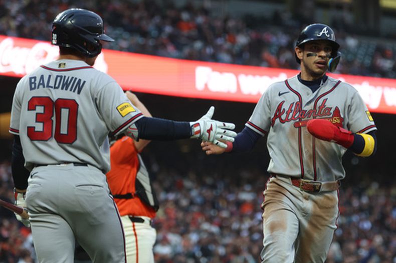 Mauricio Dubón (derecha), de los Bravos de Atlanta, es felicitado por Drake Baldwin (30) tras anotar gracias a un sencillo de Ozzie Albies durante la tercera entrada de un partido de béisbol contra los Gigantes de San Francisco, en San Francisco, el viernes 26 de junio de 2026. (Foto AP/Jed Jacobsohn)