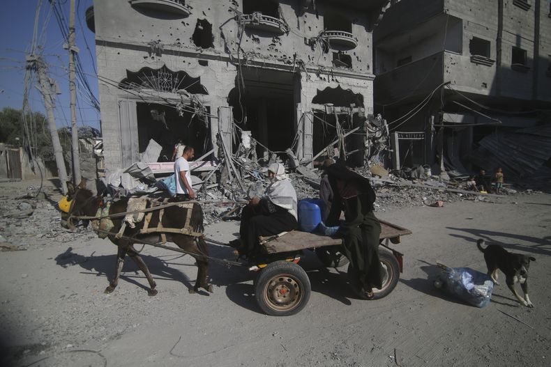 Palestinos abandonan sus casas tras los ataques aéreos israelíes al campo de refugiados de Rafa en el sur de la Franja de Gaza, 12 de octubre de 2023. (AP Foto/Hatem Ali)