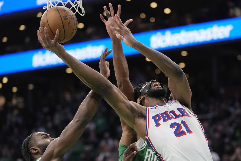 Joel Embiid, de los 76ers de Filadelfia, dispara frente a Jaylen Brown, de los Celtics de Boston, en el encuentro del miércoles 25 de diciembre de 2024 (AP Foto/Michael Dwyer)