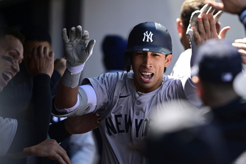 Oswaldo Cabrera de los Yankees de Nueva York es felicitado en el dugout tras batear un jonrón de dos carreras frente al relevista de los Guardianes de Cleveland Nick Sandlin en la sexta entrada del primer juego de la doble cartelera del sábado 13 de abril del 2024. (AP Foto/David Dermer)