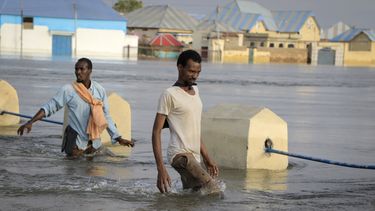 Hombres caminando en una calle inundada en la ciudad de Beledweyne, Somalia, el lunes 15 de mayo de 2023. La Oficina de Naciones Unidas para la Coordinación de Asuntos Humanitarios estima que 460.000 personas se han visto afectadas por las inundaciones causadas por las lluvias desde mediados de marzo. (AP Foto)