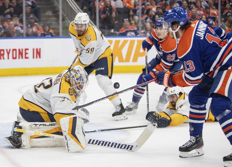 El portero de los Nashville Predators Kevin Lankinen observa el puck mientras su compañero Roman Josi (59) y Ryan Nugent-Hopkins y Mattias Janmark de los Oilers de Edmonton pelean por el balón el 27 de enero del 2024. (Amber Bracken/The Canadian Press via AP)