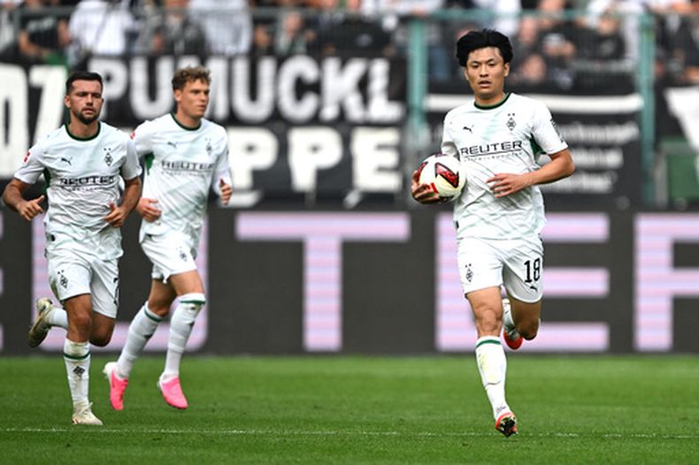 Shuto Machino, del Mönchengladbach (a la derecha), celebra tras marcar un gol durante el partido de la Bundesliga alemana de fútbol entre el Borussia Mönchengladbach y el 1. FSV Mainz 05 en Mönchengladbach, Alemania, el sábado 19 de septiembre de 2026. (Federico Gambarini/dpa vía AP)