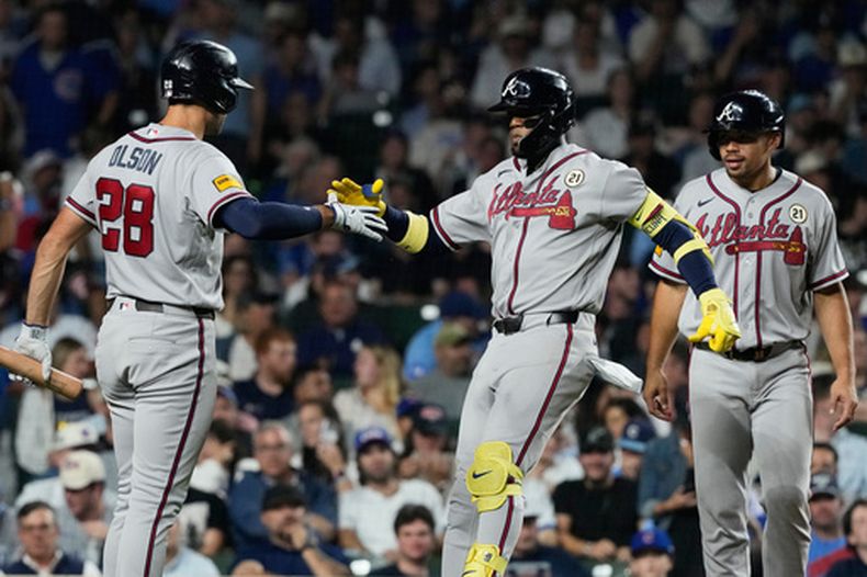 El venezolano de los Bravos de Atlanta Ronald Acuña Jr. celebra con Matt Olson y Drake Baldwin tras batear un jonrón de dos anotaciones en la sexta entrada ante los Cachorros de Chicago el martes 15 de septiembre del 2026. (AP Foto/Nam Y. Huh)