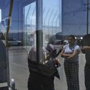 ARCHIVO - Personas esperan afuera de Glass House Farms, en Camarillo, California, un día después de una redada de inmigración en las instalaciones, el viernes 11 de julio de 2025. (AP Foto/Jae C. Hong, Archivo)