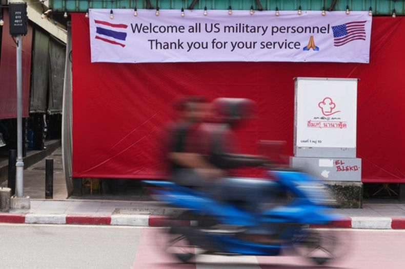 Una mototaxi pasa por delante de una pancarta en Pattaya, Tailandia, el 1 de septiembre de 2026. (AP Foto/Sakchai Lalit)