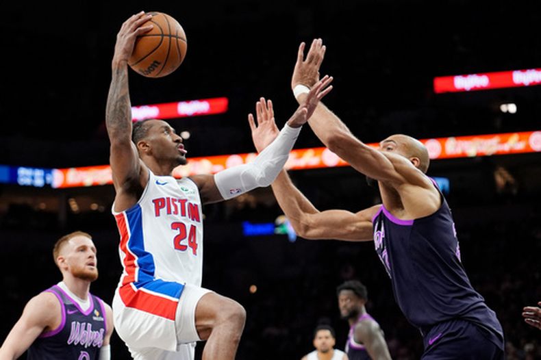 Daniss Jenkins, de los Pistons de Detroit, salta a la cesta frente al francés Rudy Gobert, de los Timberwolves de Minnesota, el sábado 28 de marzo de 2026 (AP Foto/Bruce Kluckhohn)