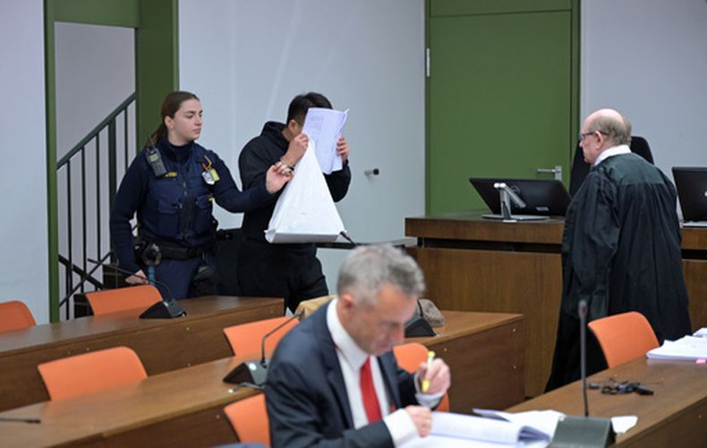 Un acusado se cubre el rosto al llegar a un juicio a una red de hombres en su mayoría chinos, organizados en grupos de chat para aconsejarse sobre cómo drogar y violar a mujeres en su mayoría chinas, en Múnich, Alemania, el 2 de febrero de 2026. (Malin Wunderlich/dpa via AP)
