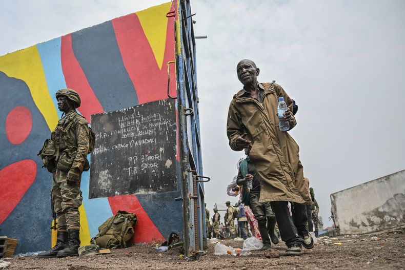 Soldados del gobierno y agentes de la policía (en la derecha) que se rindieron ante los rebeldes del grupo M23 suben a camiones que los llevarán a un sitio no divulgado, en la ciudad de Goma, en la República Democrática del Congo, el jueves 30 de enero de 2025. (AP Foto/Moses Sawasawa)