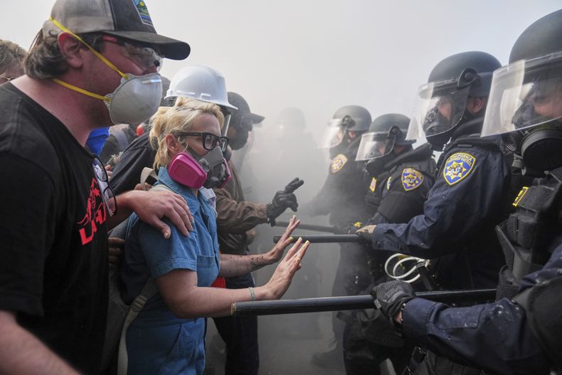 Manifestantes se enfrentan con la policía en la autopista 101, cerca del centro metropolitano de detención, el domingo 8 de junio de 2025, en Los Ángeles. (AP Foto/Jae C. Hong)