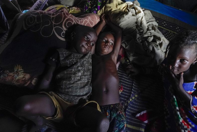 Niños descansan en una choza a un costado de una autopista, el lunes 31 de julio de 2023, en Niamey, Níger. (AP Foto/Sam Mednick)
