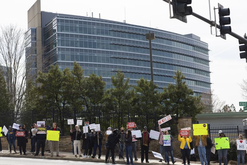Manifestantes protestan contra los despidos en los Centros para el Control y la Prevención de Enfermedades (CDC) frente a la sede de los CDC en Atlanta el martes 18 de febrero de 2025. (Arvin Temkar/Atlanta Journal-Constitution via AP)