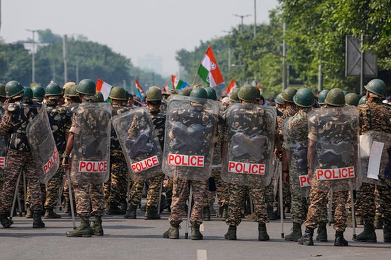 Personal de seguridad con equipo antimotines llega para escoltar a trabajadores del partido opositor Congreso, que se reúnen en una marcha hacia la Corte Suprema para exigir la renuncia del jefe electoral del país, Gyanesh Kumar, en Nueva Delhi, India, el lunes 12 de octubre de 2026. (AP Foto/Manish Swarup)