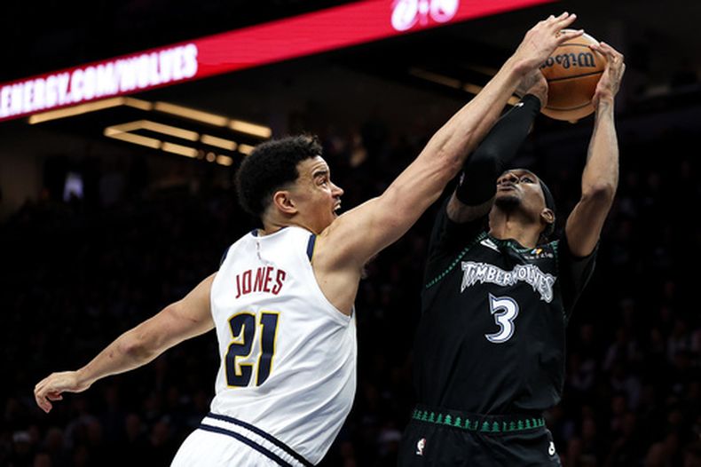 ARCHIVO - Spencer Jones (21), de los Nuggets de Denver, intenta bloquear un tiro de Jaden McDaniels (3), de los Timberwolves de Minnesota, durante la segunda mitad del sexto juego de la serie de primera ronda de playoffs del baloncesto de la NBA, el 30 de abril de 2026, en Minneapolis. (AP Foto/Matt Krohn, Archivo)