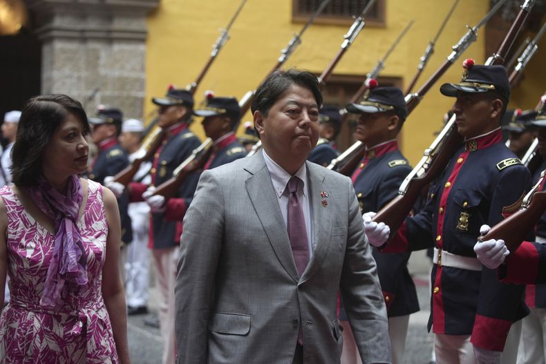 El canciller japonés, Yoshimasa Hayashi, a la derecha, y la ministra de Asuntos Exteriores de Perú, Ana Cecilia Gervasi, caminan frente a la guardia de honor durante la ceremonia de bienvenida en la Cancillería en Lima, Perú, el miércoles 3 de mayo de 2023. Hayashi está de visita en Perú por dos días. (AP Foto/Guadalupe Pardo)
