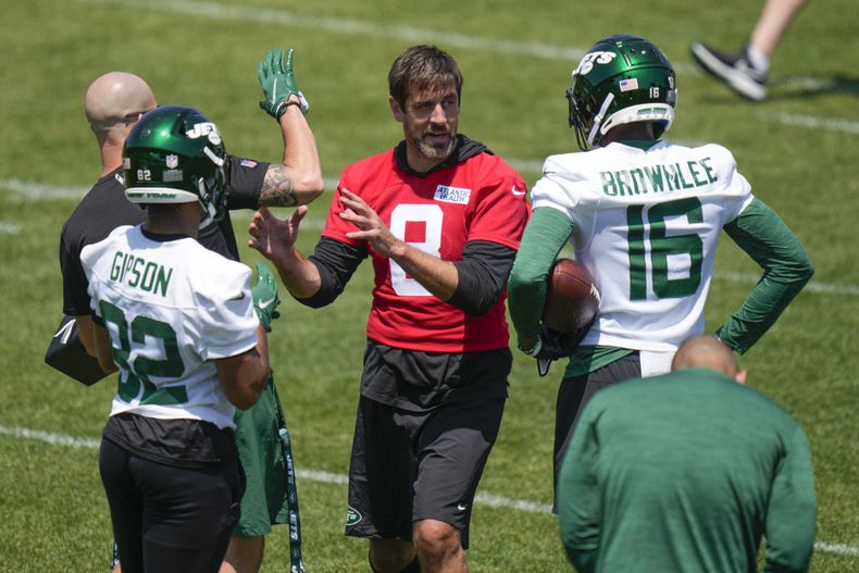 Aaron Rodgers, centro, quarterback de los Jets de Nueva York, platica con sus compañeros de equipo durante un ejercicio en el campo de entrenamiento de la NFL en las instalaciones del equipo en Florham Park, Nueva Jersey, el miércoles 31 de mayo de 2023. (AP Foto/Seth Wenig)