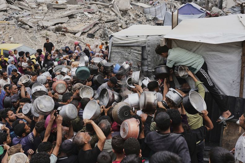 Palestinos tratan de conseguir comida en un comedor social en Jabalia, en el norte de la Franja de Gaza, el 15 de mayo de 2025. (AP Foto/Jehad Alshrafi)