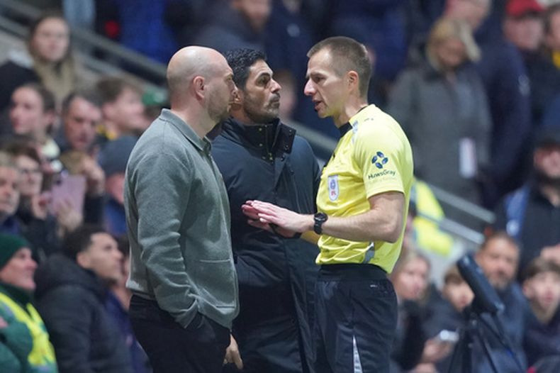 El entrenador del Fleetwood, Matt Lawlor, a la izquierda, y el director técnico del Arsenal, Mikel Arteta, al centro, conversan con el árbitro durante un partido de fútbol de la Copa de la Liga de Inglaterra entre el Fleetwood Town y el Arsenal en Fleetwood, Inglaterra, el martes 27 de octubre de 2026. (Foto AP/Ian Hodgson)
