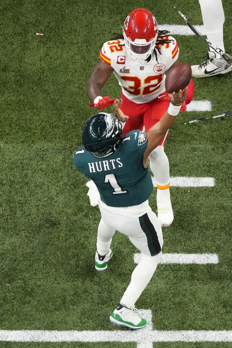 Jalen Hurts (1), quarterback de los Eagles de Filadelfia, lanza una intercepción mientras es presionado por Nick Bolton (32), linebacker de los Chiefs de Kansas City, durante la primera mitad del Super Bowl 59, el domingo 9 de febrero de 2025, en Nueva Orleans. (AP Foto/Godofredo A. Vásquez)