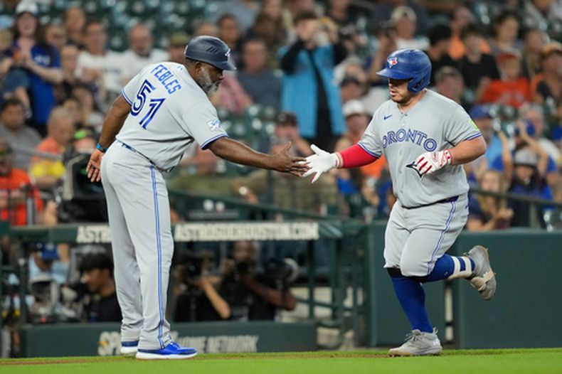 Alejandro Kirk, derecha, de los Azulejos de Toronto, celebra con el coach de tercera base, Carlos Febles (51), después de batear un jonrón en contra de los Astros de Houston durante la segunda entrada del juego de béisbol de Grandes Ligas, el lunes 3 de agosto de 2026, en Houston. (AP Foto/David J. Phillip)
