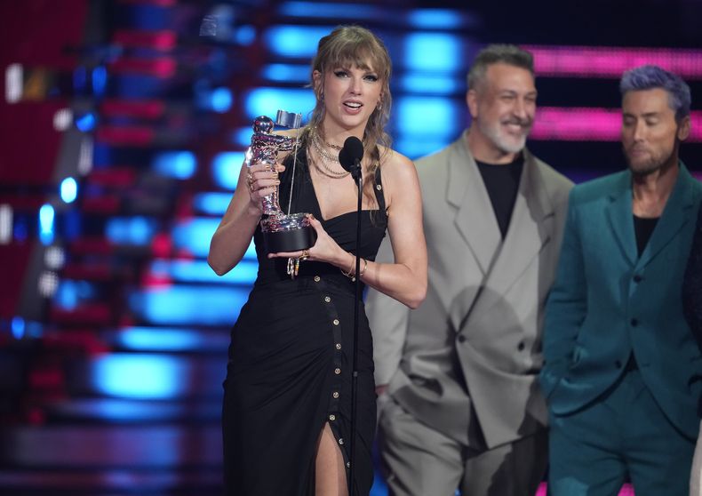 Taylor Swift recibe el premio a mejor pop por Anti-Hero en los Premios MTV a los videos musicales el martes 12 de septiembre de 2023 en el Prudential Center en Newark, Nueva Jersey. Joey Fatone, centro, y Lance Bass ven desde la derecha. (Foto Charles Sykes/Invision/AP)