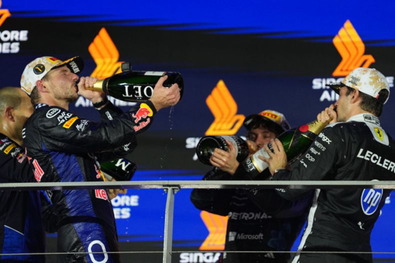 Desde la izquierda: el piloto de Red Bull, Max Verstappen, de Países Bajos; el piloto de Mercedes, Andrea Kimi Antonelli, de Italia; y el piloto de Ferrari, Charles Leclerc, de Mónaco, celebran en el podio tras la carrera del Gran Premio de Singapur de la Fórmula 1 en Singapur, el domingo 11 de octubre de 2026. (Foto AP/Ng Han Guan)