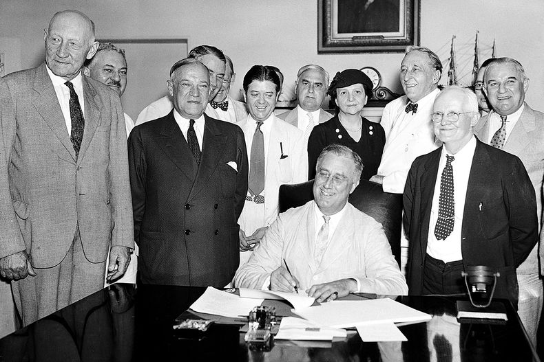 ARCHIVO – El presidente Franklin Roosevelt firma la Ley de Seguridad Social en Washington, el 14 de agosto de 1935. (AP Foto, Archivo)