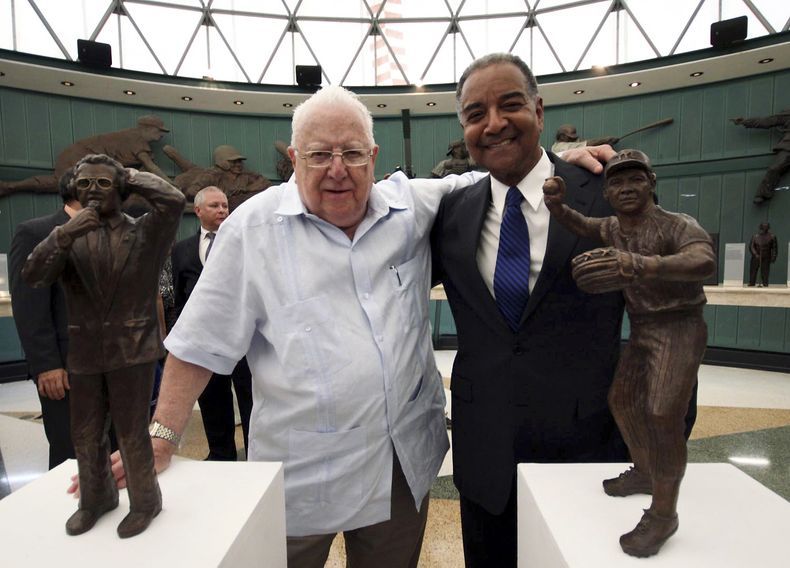 Juan Ven&eacute;, izquierda, y D&aacute;maso Blanco posan juntos a sus estatuas de bronce durante la ceremonia de exaltaci&oacute;n al Sal&oacute;n de la Fama del b&eacute;isbol de Venezuela, el martes 23 de septiembre de 2014. (AP Foto/Hector Bencomo)