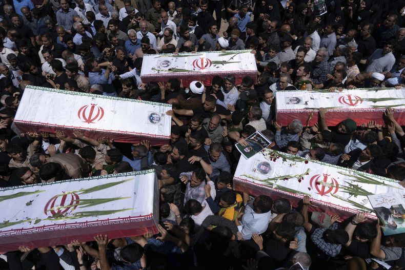 Varias personas cargan con los féretros de cinco hombres -que no fueron identificados de inmediato- que habrían muerto en ataques israelíes, durante su funeral en la ciudad de Khorramabad, Irán, el 16 de junio de 2025. (AP Foto/Aziz Babanezhad/Tasnim News Agency)