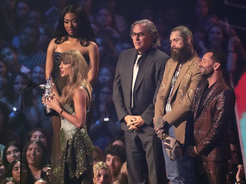 Taylor Swift, centro, y Post Malone, tercero de izquierda derecha tras Swift, reciben el premio al video del año por Fortnight durante los Premios MTV a los Videos Musicales el miércoles 11 de septiembre de 2024 en la Arena UBS en Elmont, Nueva York. La presentadora Megan Thee Stallion, desde el extremo izquierdo, el cinefotógrafo Rodrigo Prieto y Ethan Tobman miran. (Foto Charles Sykes/Invision/AP)