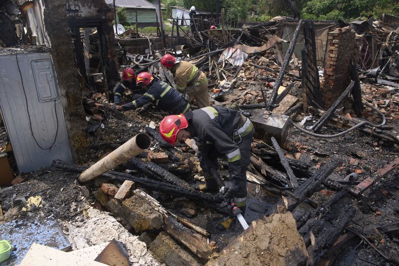 Rescatistas apagan un incendio en una vivienda destruida por un ataque ruso con drones, el jueves 5 de junio en el poblado de Pryluky, Ucrania. (AP Foto/Evgeniy Maloletka)
