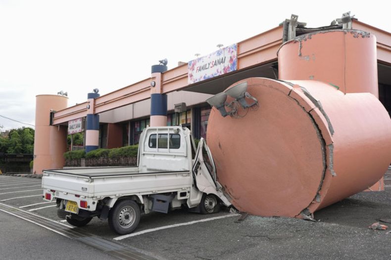 Un camión pequeño yace aplastado por una columna que se desplomó de un salón de pachinko (un juego de apuestas), el miércoles 29 de julio de 2026, un día después de un terremoto, en Uki, prefectura de Kumamoto. (Kai Naito/Kyodo News vía AP)