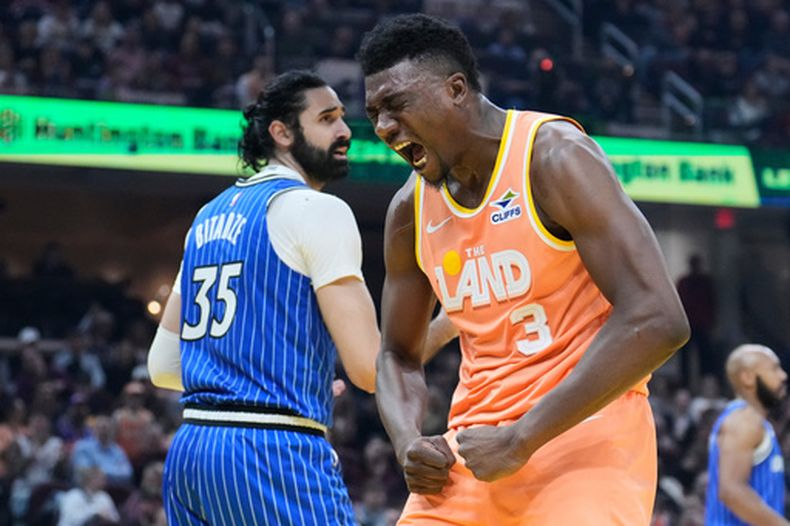 El pívot de los Cavaliers de Cleveland, Thomas Bryant (3), grita tras realizar una clavada ante el pívot del Magic de Orlando, Goga Bitadze (35), en la primera mitad de un juego de baloncesto de la NBA en Cleveland, el martes 24 de marzo de 2026. (Foto AP/Sue Ogrocki)