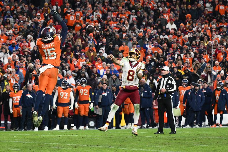 Nik Bonitto (15), linebacker de los Broncos de Denver, bloquea un pase lanzado por Marcus Mariota (8), quarterback de los Commanders de Washington, en un intento de conversión de dos puntos fallida en el tiempo extra del partido de la NFL del domingo 30 de noviembre de 2025, en Landover, Maryland. (AP Foto/Nick Wass)