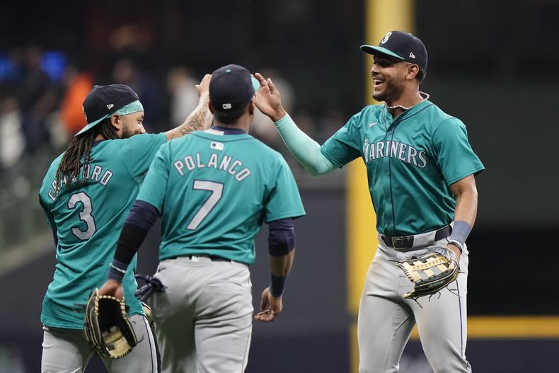 El dominicano de los Marineros de Seattle Julio Rodríguez (derecha) celebra junto a J.P. Crawford (3) y su compatriota Jorge Polanco (7) luego del triunfo sobre los Cerveceros de Milwaukee, el sábado 6 de abril de 2024, en Milwaukee. (AP Foto/Aaron Gash)