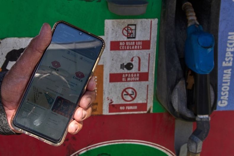 El jubilado Jorge Reyes muestra su teléfono con la aplicación El Ticket, que se utiliza para reservar un lugar en la fila para comprar gasolina racionada en La Habana, Cuba, el lunes 16 de febrero de 2026. (Foto AP/Ramón Espinosa)