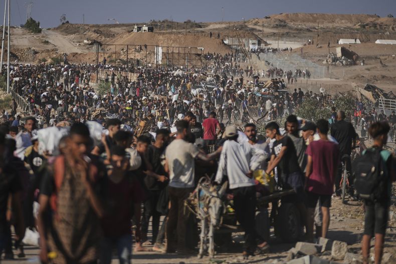 Palestinos cargan con paquetes de ayuda humanitaria cerca de un centro de distribución de la Fundación Humanitaria de Gaza, en Jan Yunis, en el sur de la Franja de Gaza, el 26 de junio de 2025. (AP Foto/Abdel Kareem Hana)