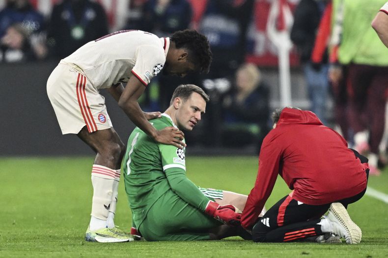 Manuel Neuer, centro, portero del Bayern Múnich, recibe atención médica durante el partido de ida de los octavos de final de la Liga de Campeones entre FC Bayern Múnich y Bayer 04 Leverkusen, el miércoles 5 de marzo de 2025, en Múnich, Alemania. (Sven Hoppe/dpa vía AP)