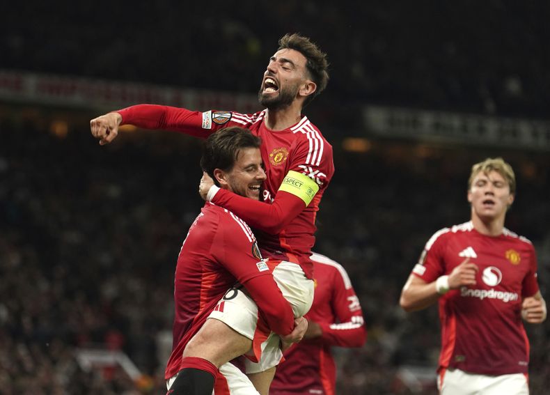Mason Mount (izquierda) celebra con Bruno Fernandes tras anotar el primer gol del Manchester United ante el Athletic Bilbao en la vuelta de las semifinales de la Liga Europa, el jueves 8 de mayo de 2025. (Martin Rickett/PA vía AP)