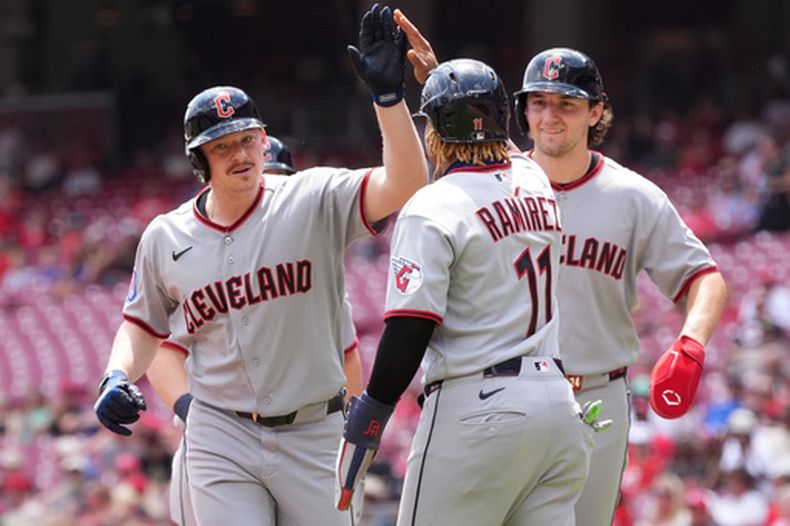 Kyle Manzardo de los Guardianes de Cleveland le da los cinco a su compañero José Ramírez tras su grand slam en la primera entrada del juego 1 de la doble cartelera ante los Rojos de Cincinnati el martes 28 de julio del 2026. (AP Foto/Kareem Elgazzar)