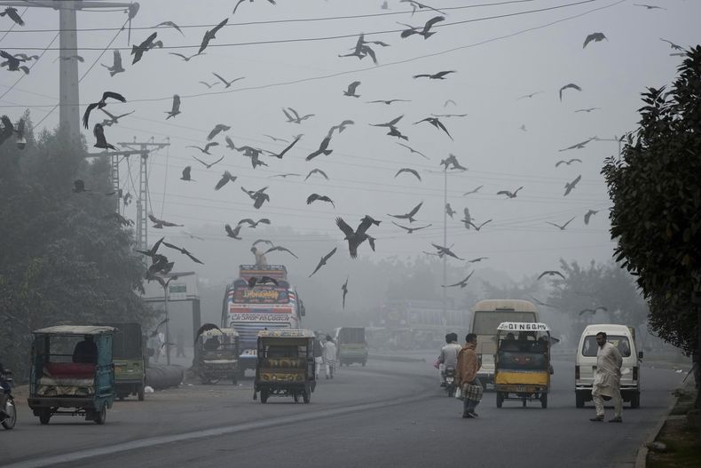 La gente cruza una carretera mientras el smog envuelve las zonas de Lahore, Pakistán, miércoles 13 de noviembre de 2024. (AP foto/K.M. Chaudary)